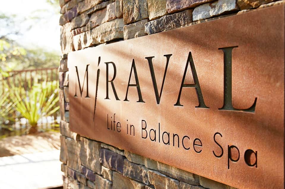 Miraval Life in Balance Spa sign mounted on stone wall with desert landscaping