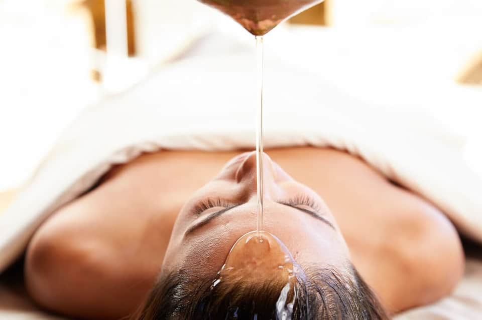 Woman receiving facial treatment with honey drip at spa