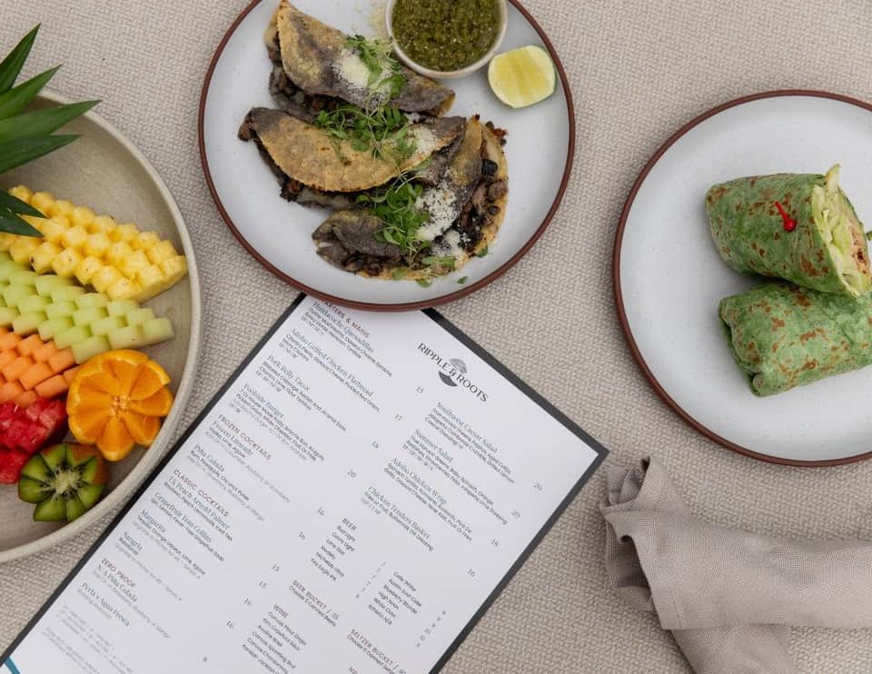 Overhead view of Mexican restaurant menu with tacos, crepes, and fresh fruit platter displayed