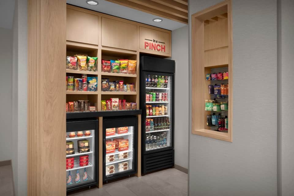 In a Pinch convenience store with wooden cabinetry, snack shelves, refrigerated beverage cooler, and freezer units