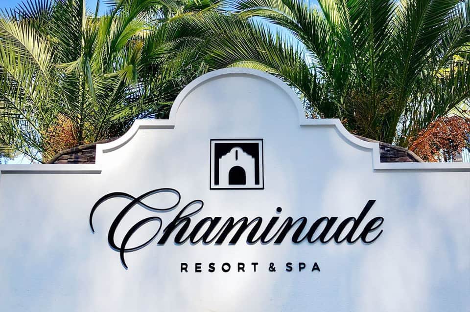 Chaminade Resort & Spa white entrance sign with palm trees and architectural details