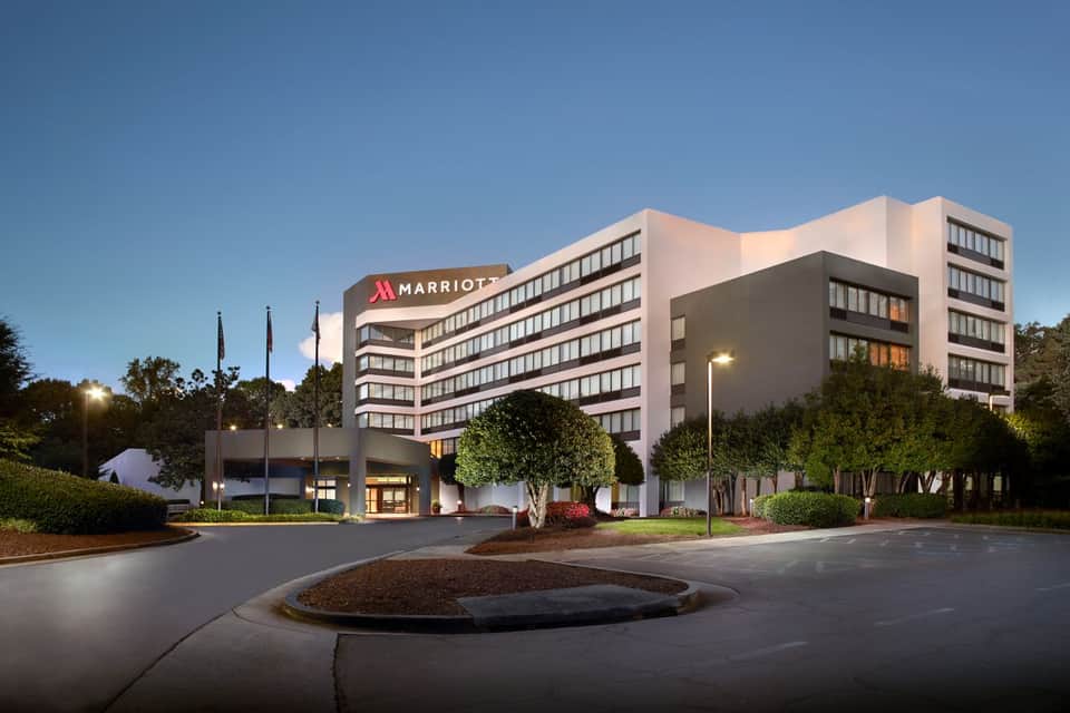 Marriott hotel exterior at dusk with modern architecture, landscaped grounds, and illuminated entrance