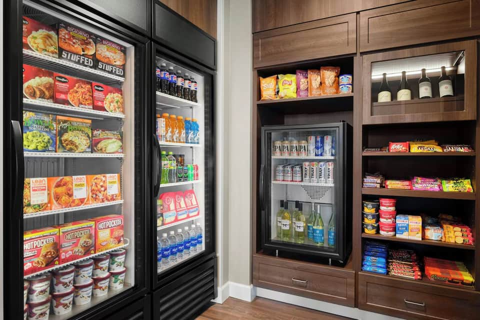 Hotel snack bar and beverage coolers with frozen foods and drinks displayed behind glass doors