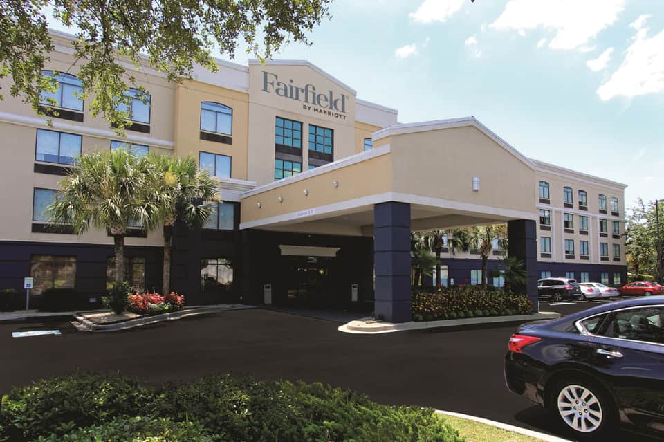 Fairfield by Marriott entrance with tan and dark exterior, porte-cochere, and landscaping