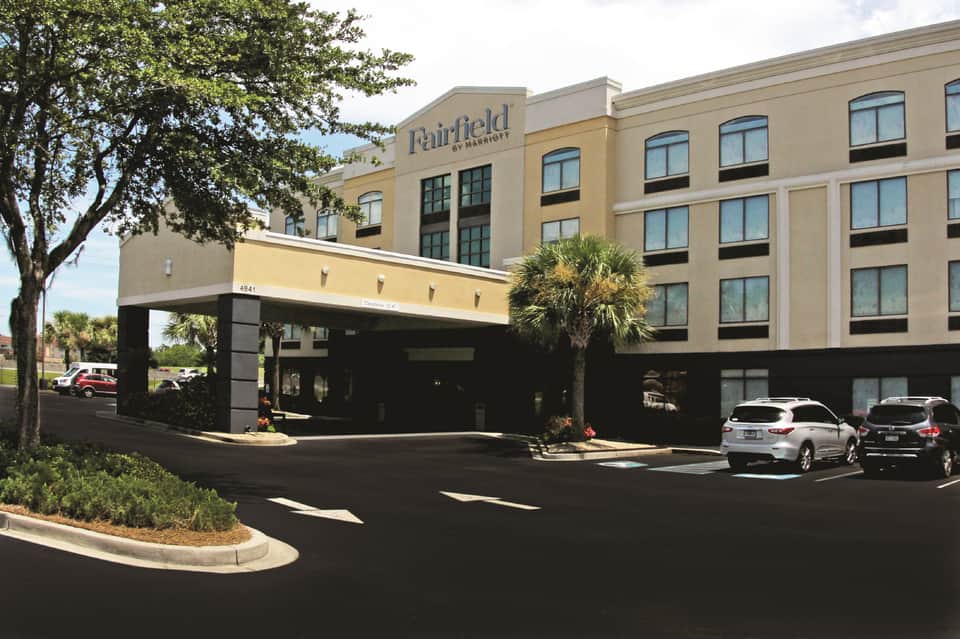 Fairfield by Marriott front entrance with covered driveway, parking area, and palm trees