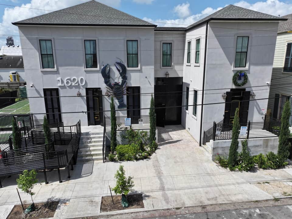Modern white townhouse exterior at 1620 with black lobster mural and columned entrance