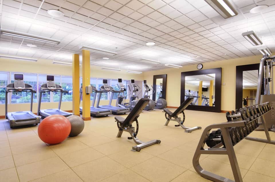 Modern fitness center featuring cardio equipment, exercise bikes, weights, and mirrors