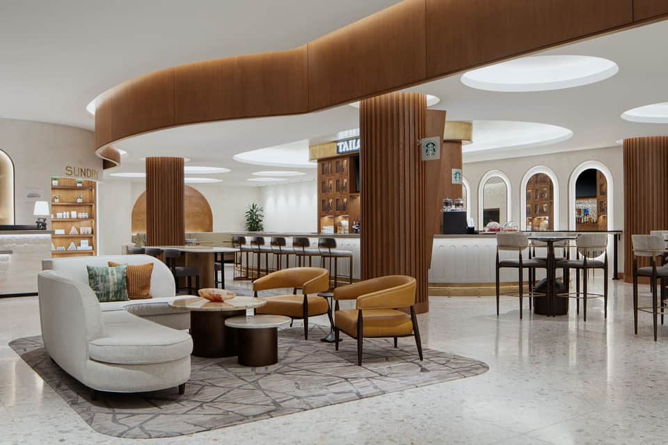 Modern hotel lobby with curved seating, wood-paneled columns, and contemporary design