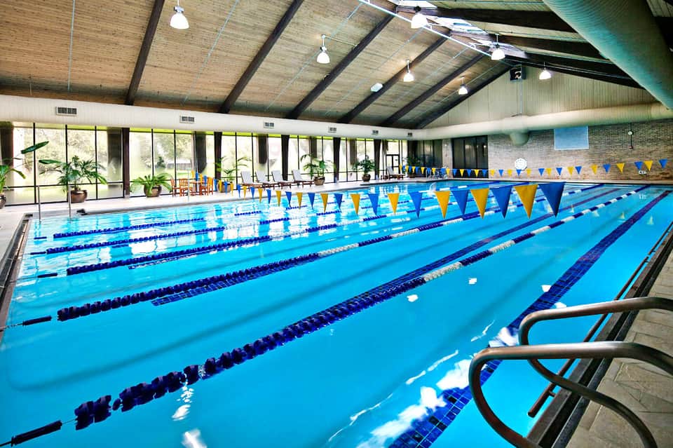 Indoor competitive swimming pool with lane dividers and blue and yellow banners