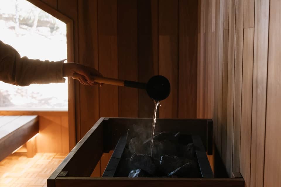 Spa treatment room with black stone basin and wooden wall features during water therapy session