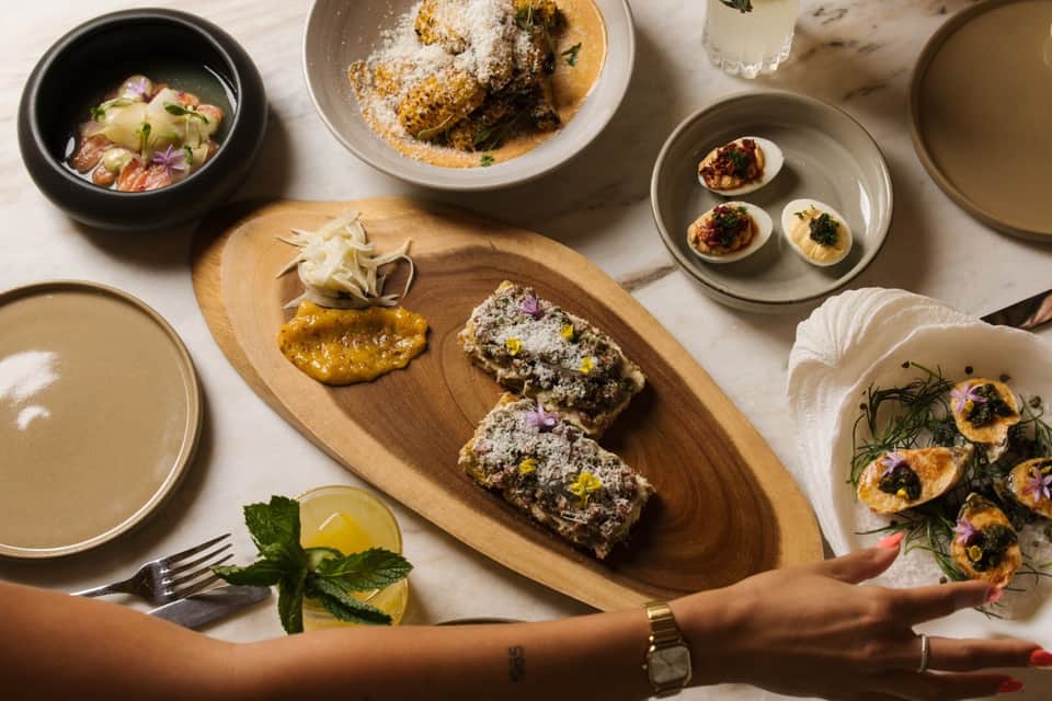 Overhead view of plated dishes including desserts, appetizers, and soups on marble surface