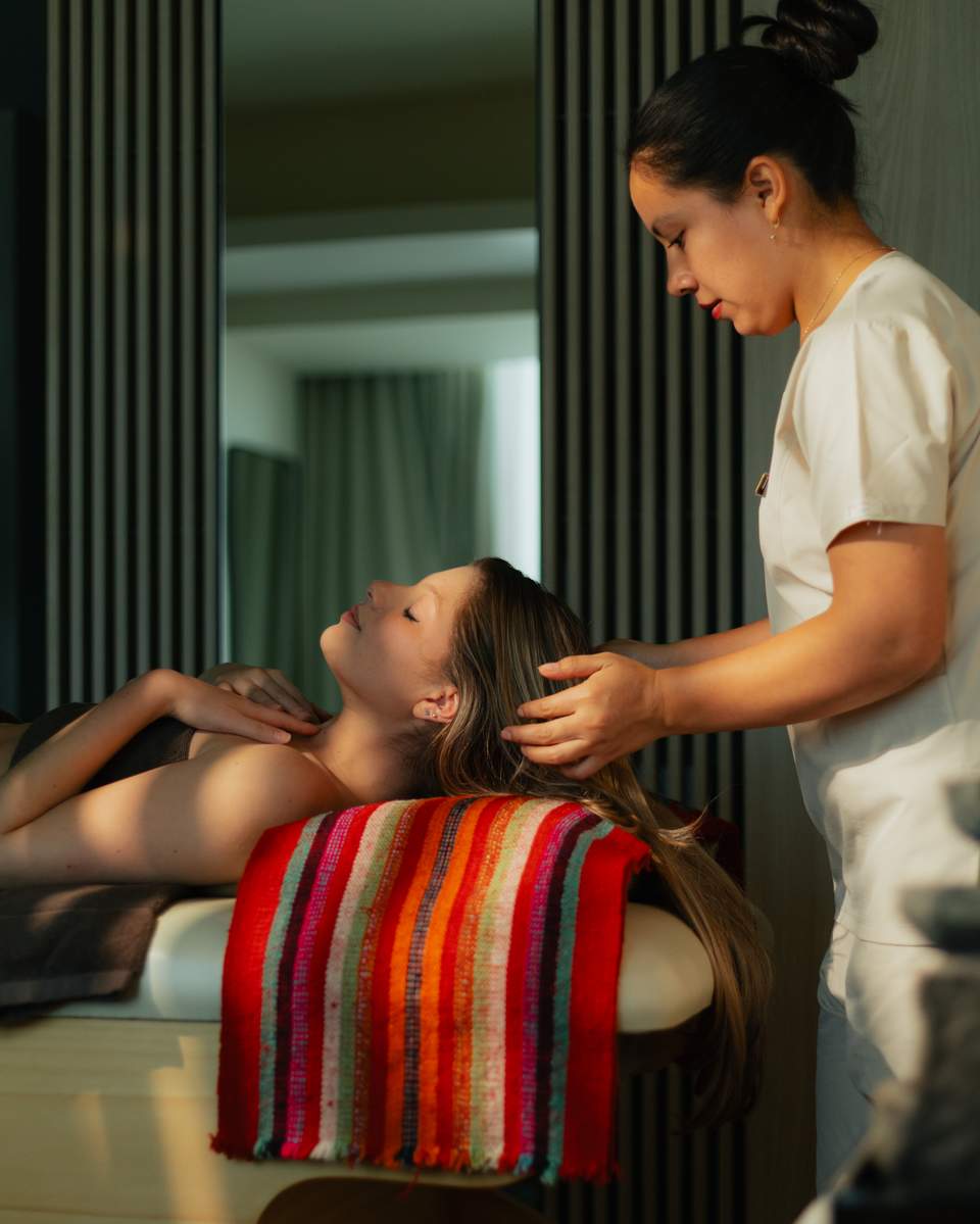 Spa therapist administering a neck and shoulder massage to a relaxed client