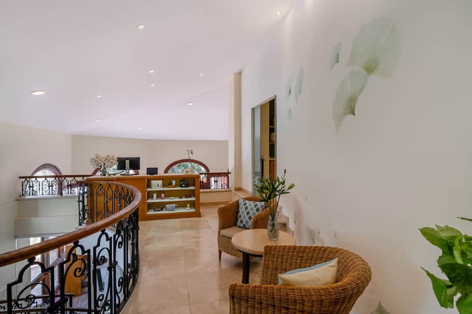 Resort lobby with spiral staircase, wicker seating, and curved railings