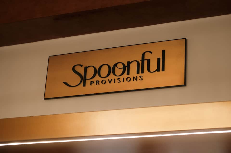Spoonful Provisions sign on cream wall with wood ceiling detail