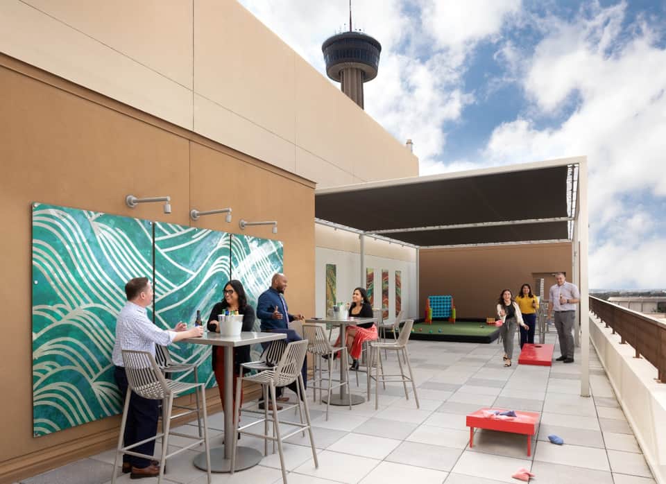 Rooftop event space with modern furniture, artwork, and Hemisfair Tower with retractable canopy