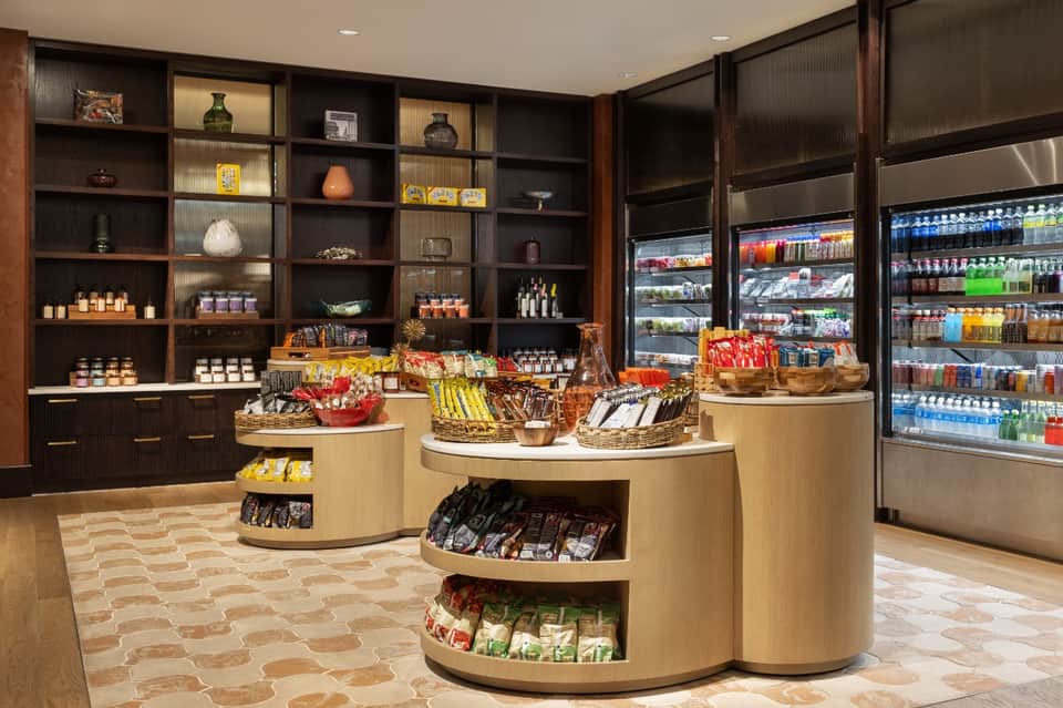 Upscale gourmet market interior with dark wood shelving, refrigerated cases, and artisanal food displays