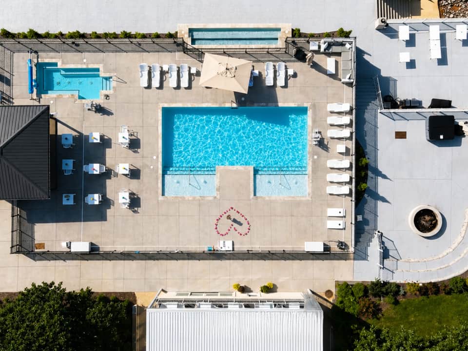 Overhead view of resort pool complex with lounge chairs and surrounding buildings