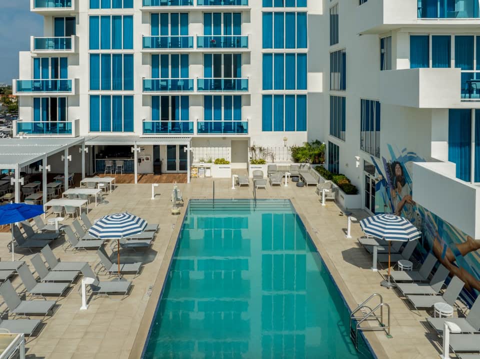 Contemporary hotel courtyard with turquoise lap pool and white modern architecture