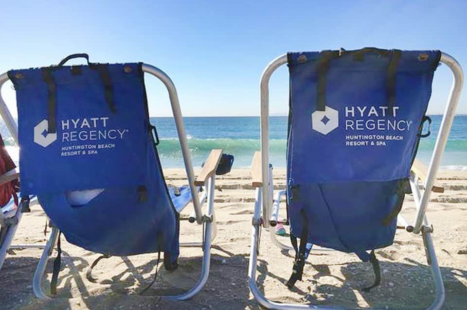 Two blue Hyatt Regency beach chairs on sand overlooking the ocean