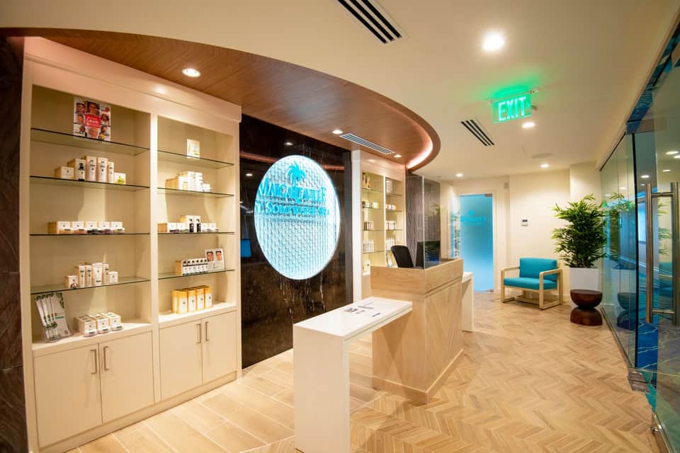 Modern spa reception area with illuminated wall feature, wooden accents, and product displays