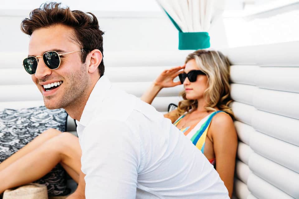 Couple enjoying time on a luxury yacht with white cushioned seating and ocean views