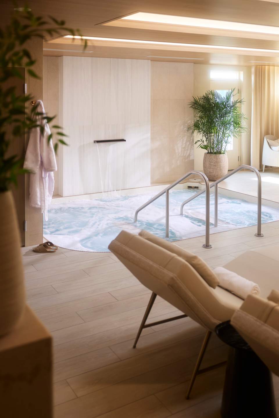 Spa pool area with white shower enclosure, plants, and comfortable seating