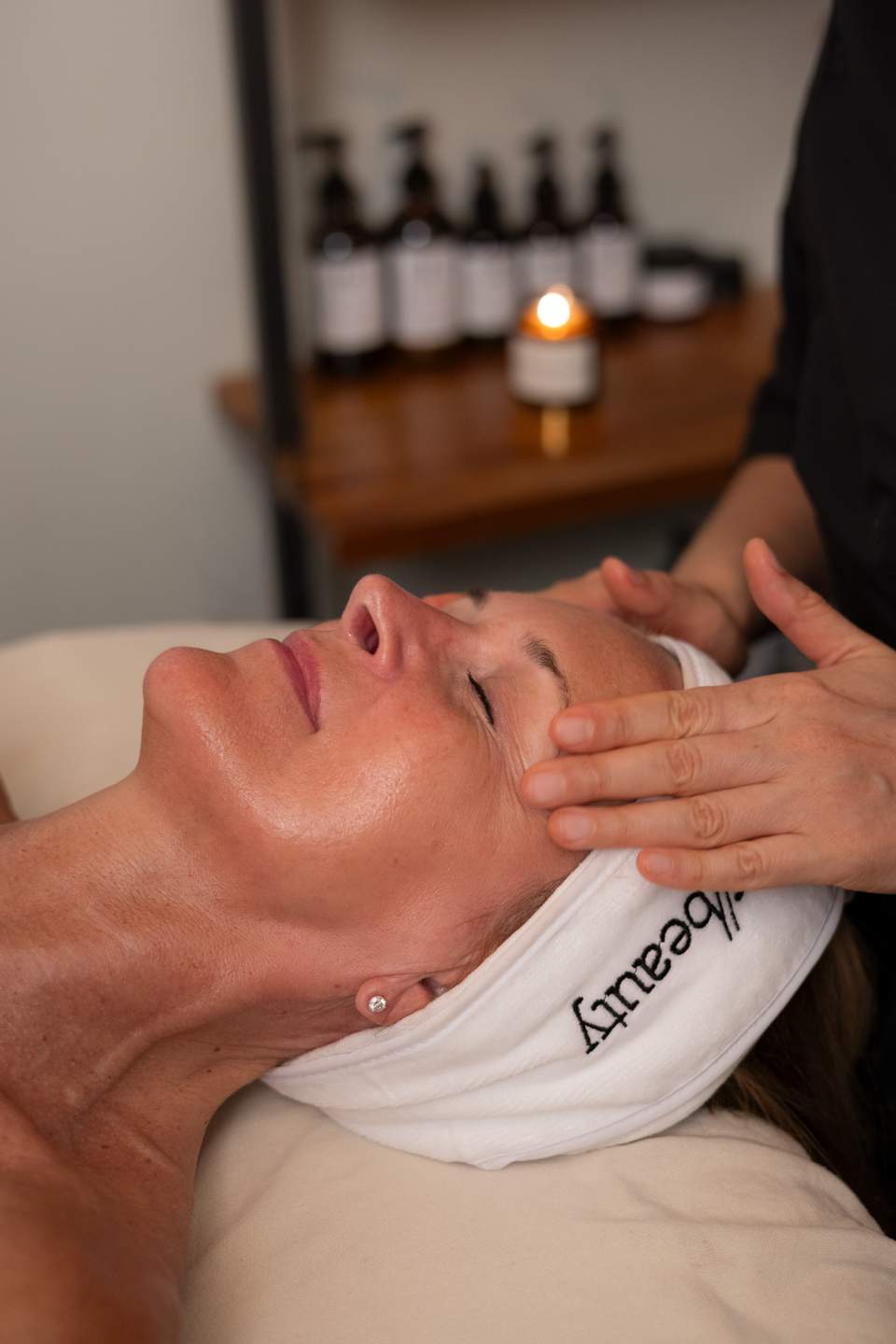 Hands-on facial massage treatment being performed on relaxed client in spa setting