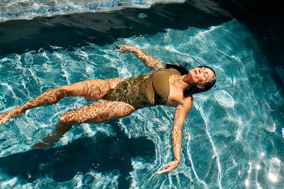 Guest floating peacefully in crystal-clear turquoise water at tropical resort beach