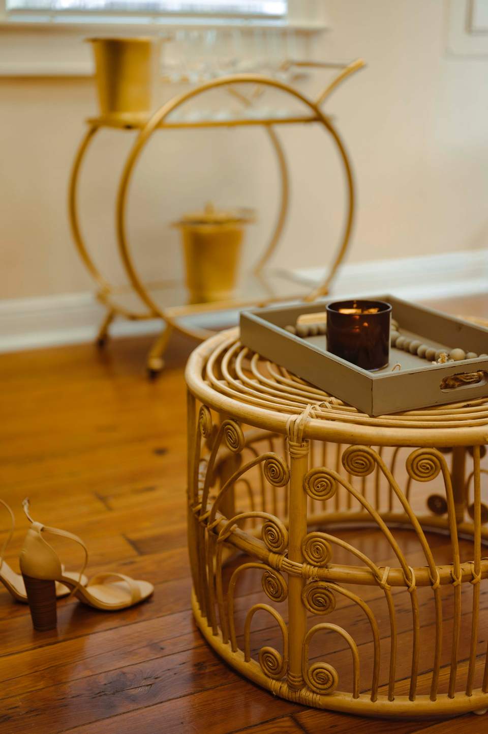 Spa room detail showing decorative gold basket with candle and beaded necklace on wooden floor