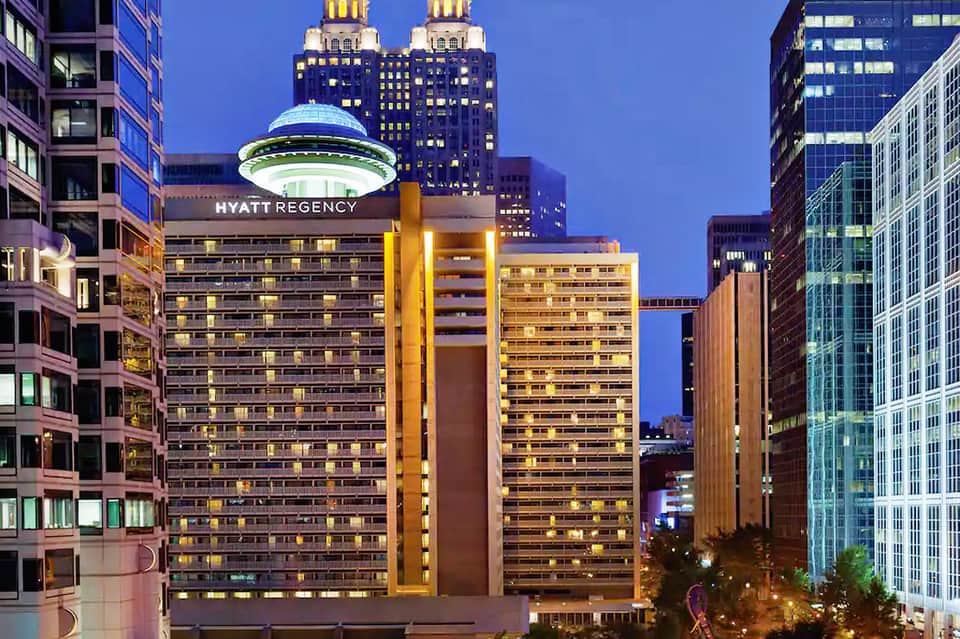 Hyatt Regency hotel building illuminated at dusk in urban skyline