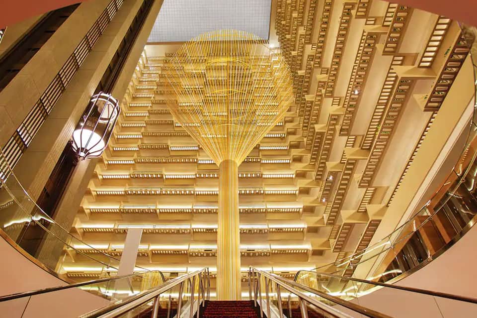 Grand hotel atrium with ornate golden ceiling and symmetrical architectural design
