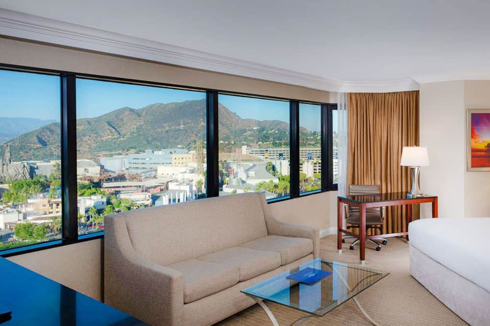 Modern hotel room with contemporary furnishings overlooking city and mountains