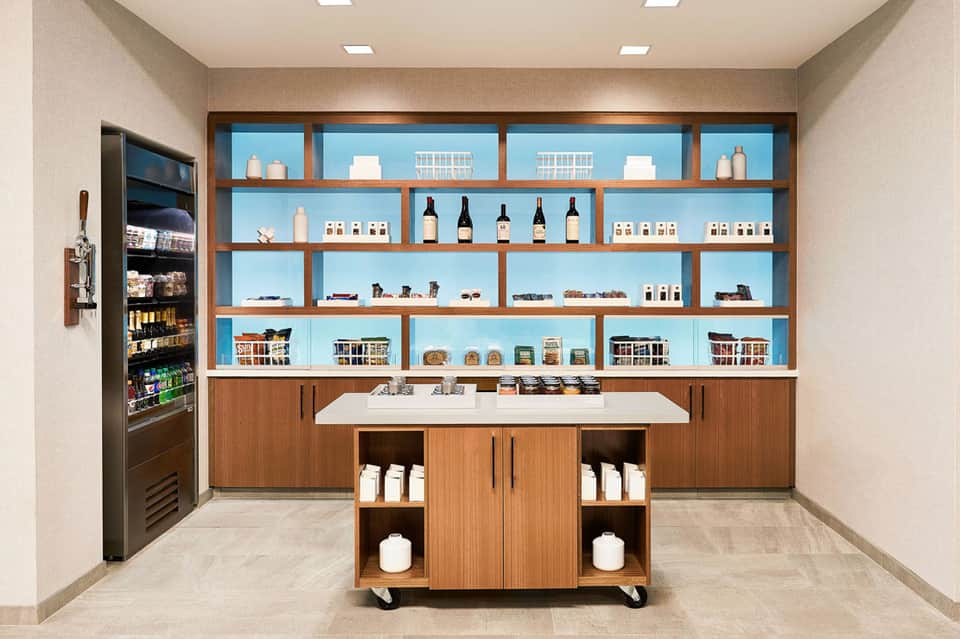 Luxury spa retail display with wooden shelving, blue-lit background, and skincare product bottles