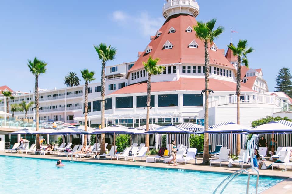 Beachfront resort with distinctive red-roofed dome and palm trees by pool