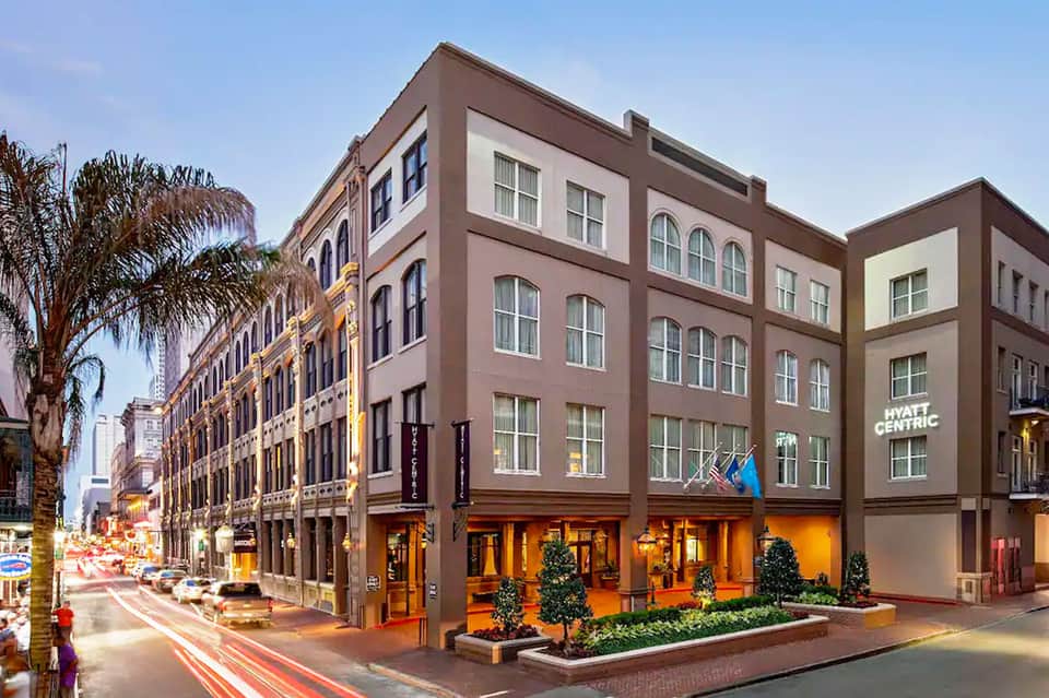 Historic downtown building facade with brown and cream exterior, storefront windows, and palm trees