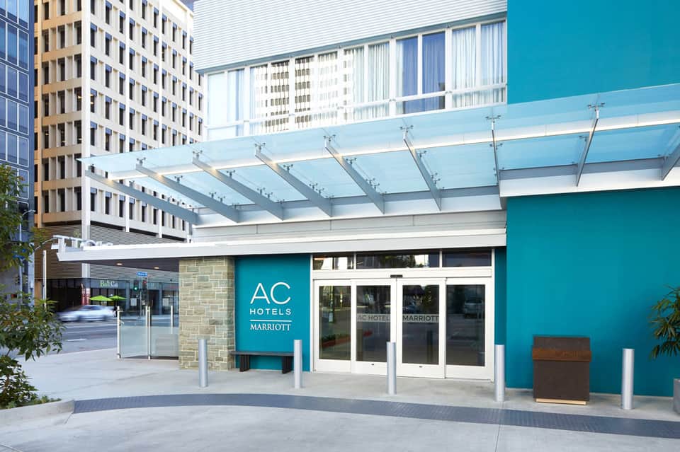 AC Hotels by Marriott turquoise entrance with glass canopy and modern architecture