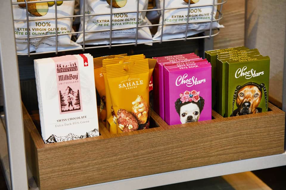 Retail display shelf with gourmet products including chocolate, olive oil, and specialty snacks