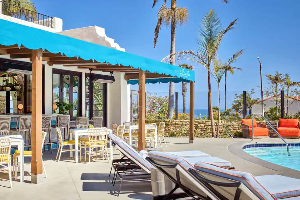Resort pool deck with turquoise awning, lounge chairs, and ocean view