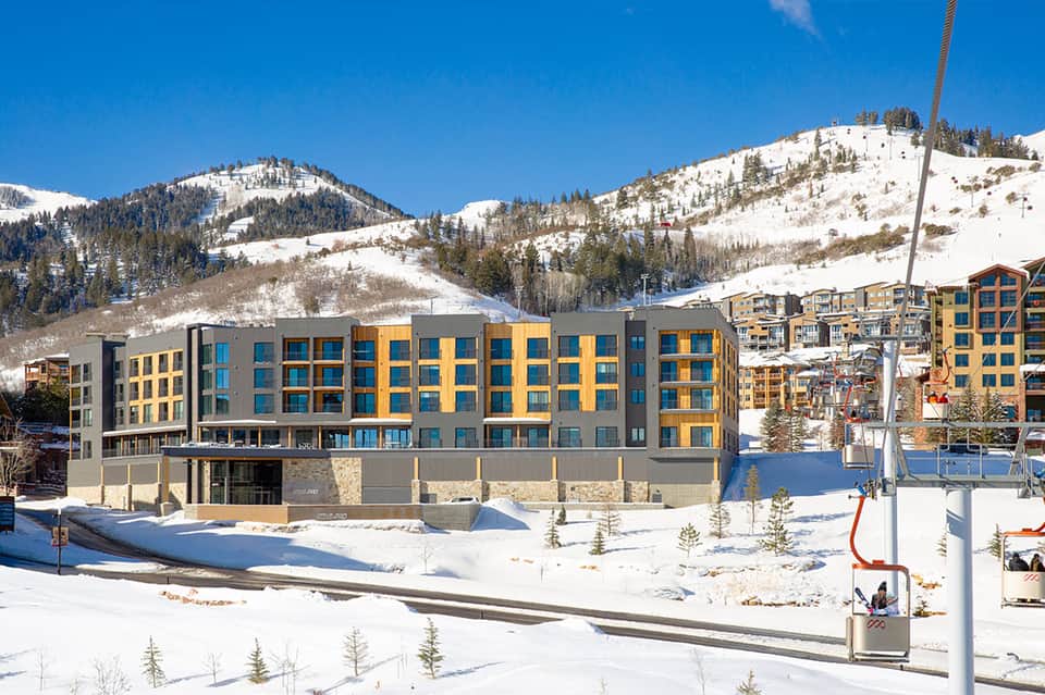 Modern yellow and gray ski resort building on snowy mountain with ski lift