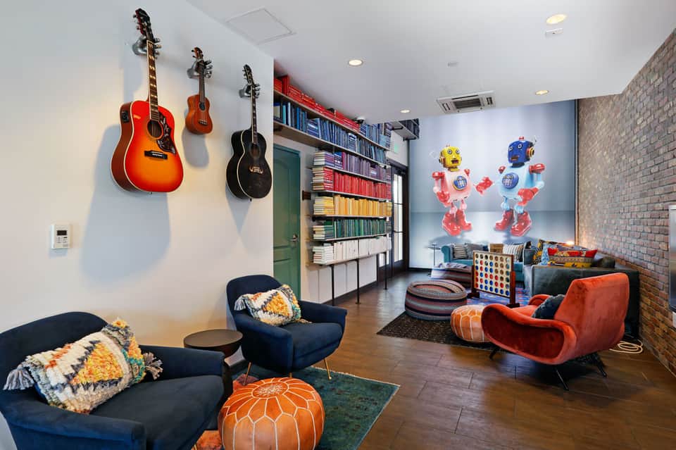 Colorful playroom with guitars on wall, robots, books, and comfortable seating
