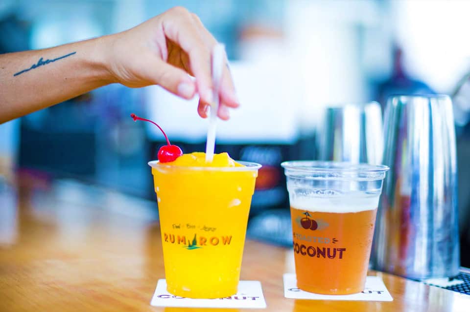 Colorful tropical drinks at a resort bar, including yellow and orange beverages