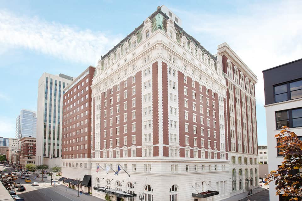 Historic brick and white stone hotel building in downtown urban setting