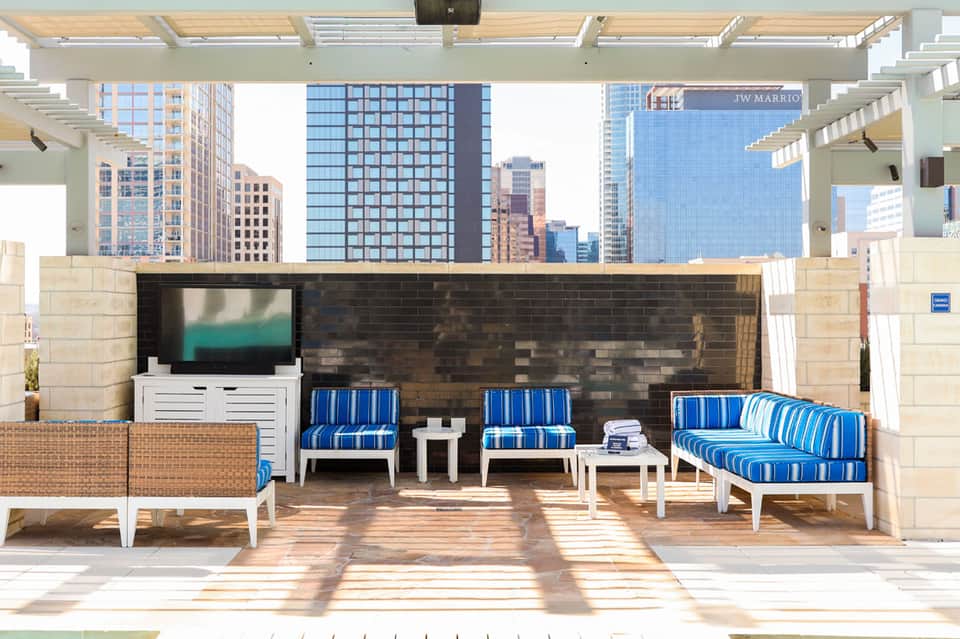 Rooftop lounge area with blue striped seating and city skyline views
