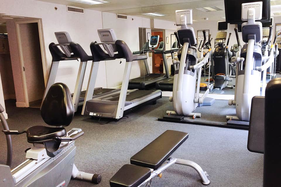 Bright fitness center with treadmills, stationary bikes, and exercise equipment