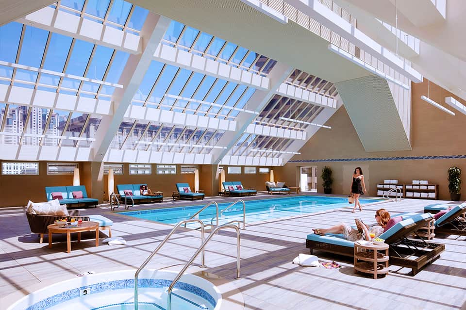 Modern indoor pool facility with skylights and lounge seating