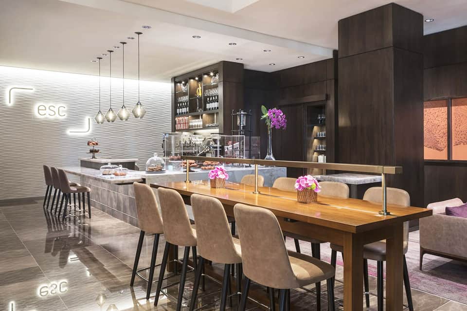 Modern lounge bar with dark wood cabinetry, pendant lights, and elegant seating at counter
