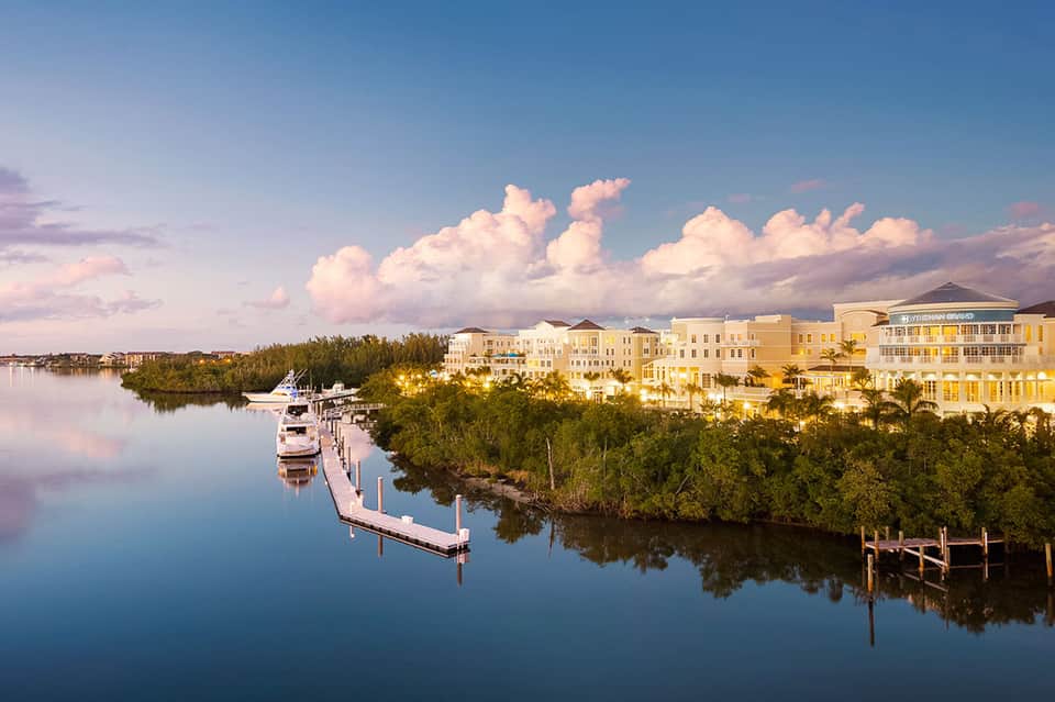 Waterfront resort buildings with boats docked at marina surrounded by mangrove trees