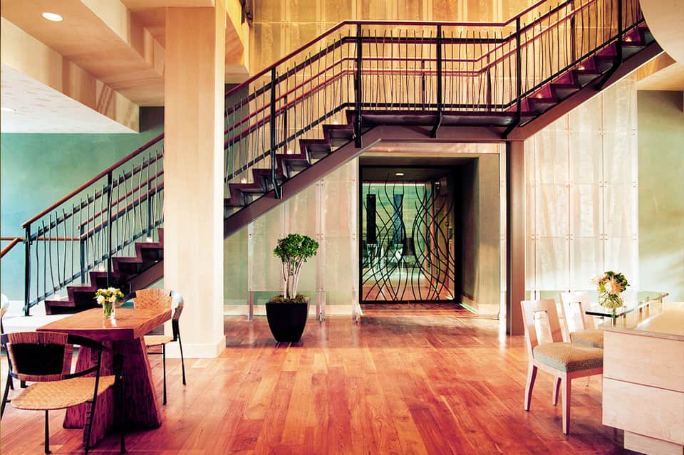 Modern multi-level interior with wooden stairs, polished hardwood floors, and contemporary furnishings