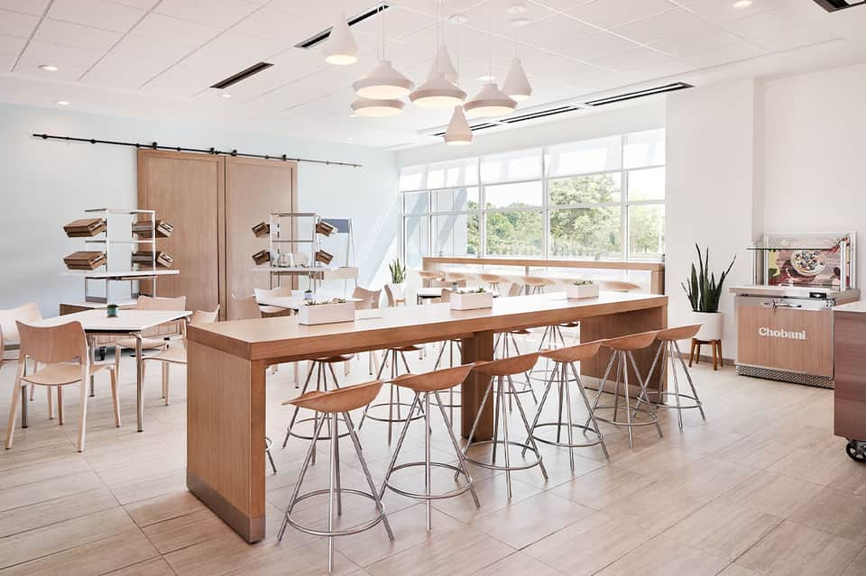 Modern hotel café interior with wood accents, bar seating, and large windows