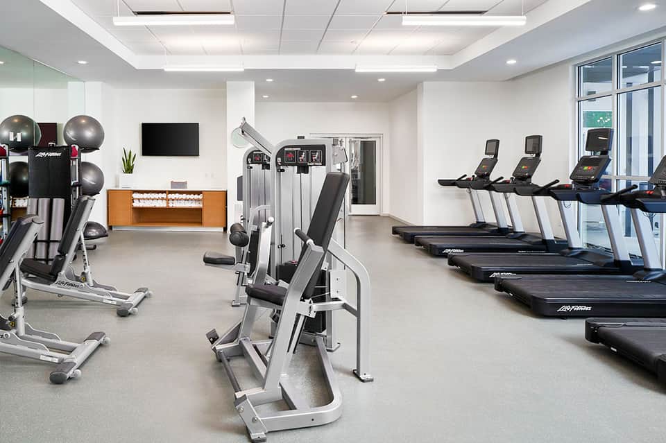 State-of-the-art fitness center with treadmills, exercise equipment, and large windows